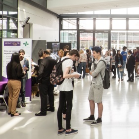 Open day attendees in discussion groups in the foyer