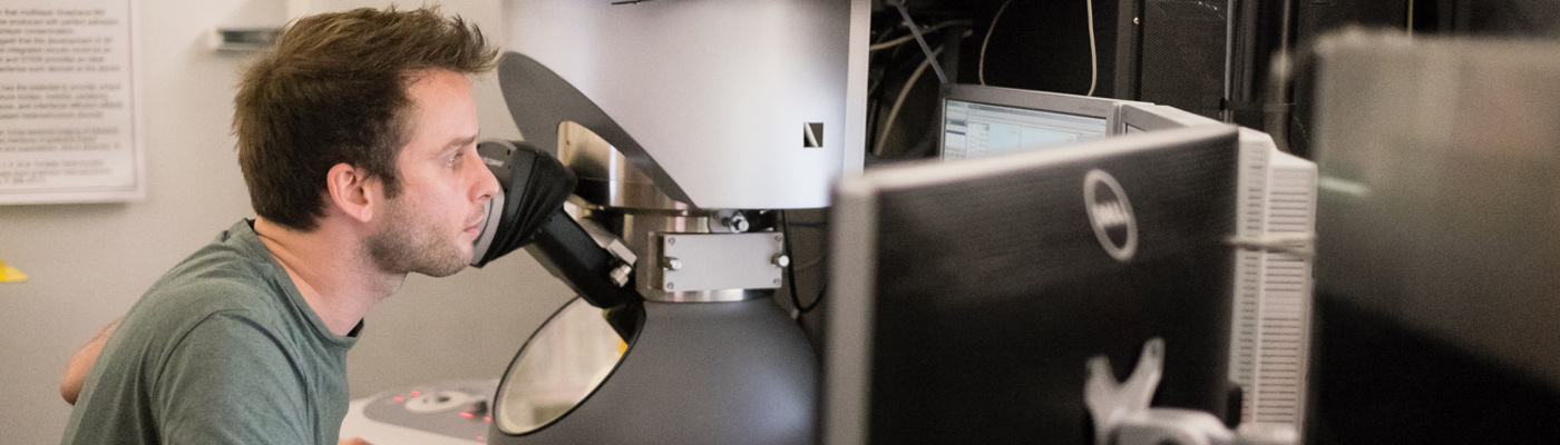 Researcher looking through microscope in a lab